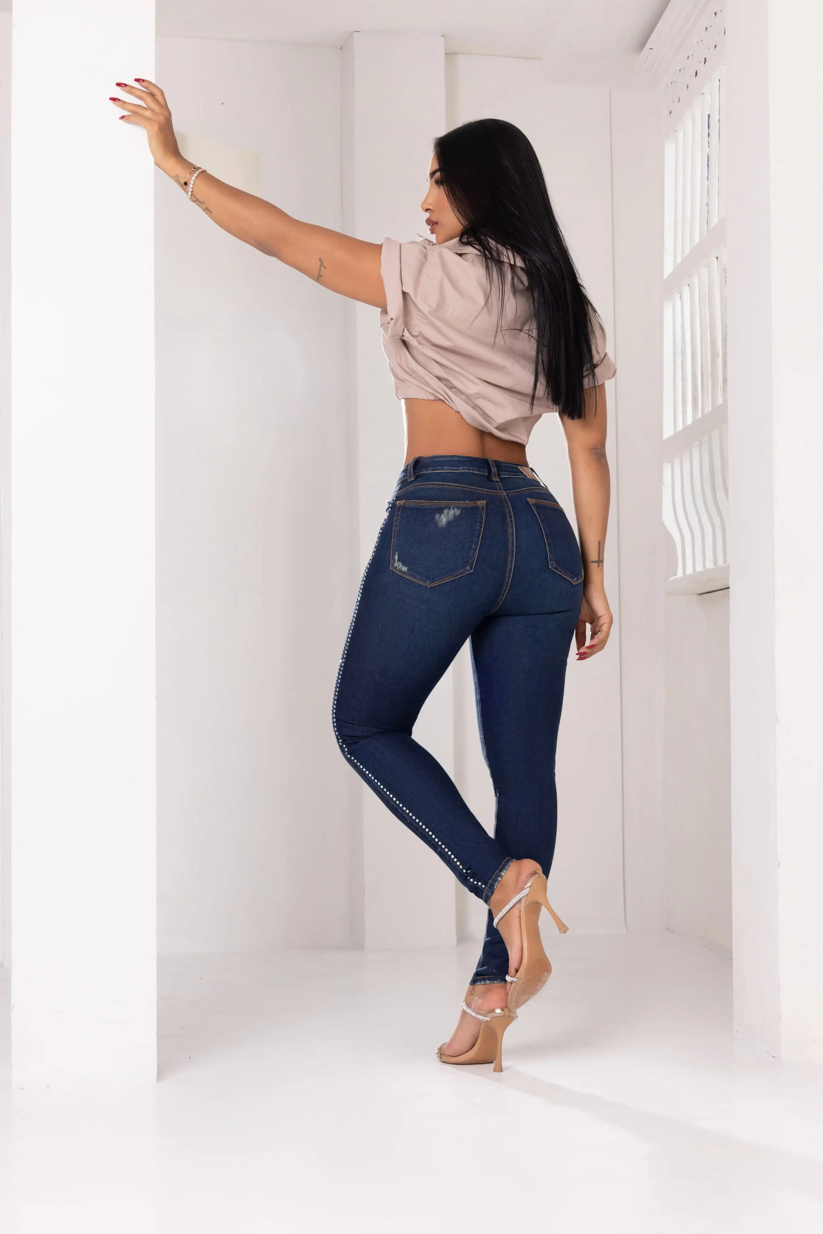 Jean skinny colombiano con realce de glúteos, vista trasera con bolsillos y costuras, cristales a lo largo del costado